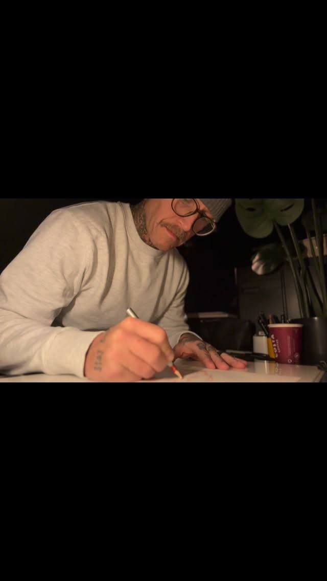 Lee drawing a design at his desk