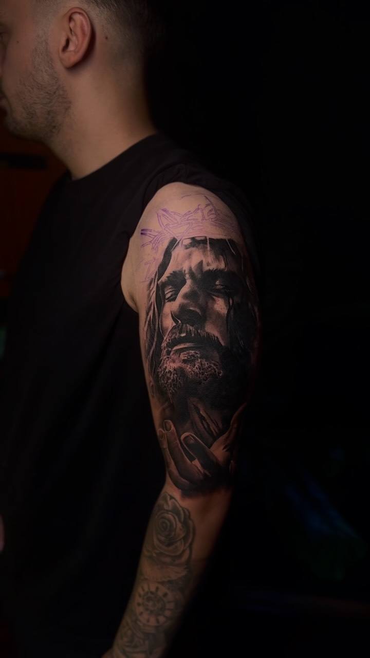 Bearded man's face on an upper arm
