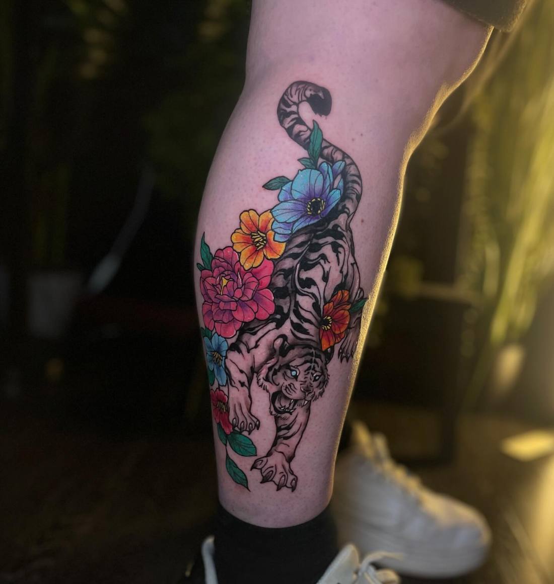 Tiger with bright flowers on a calf