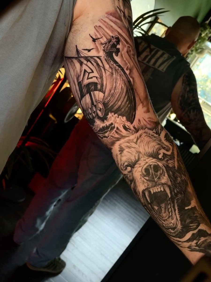 Forearm sleeve with a snarling bear and a sailing ship